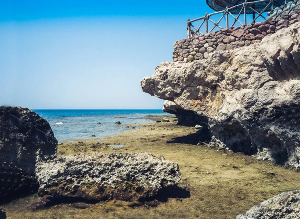 Costa del Mar Rosso con una recinzione in legno e ombrelloni a Sh — Foto Stock