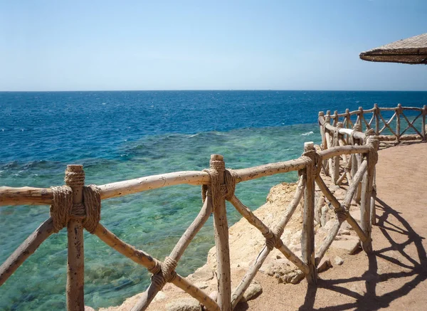 Costa del Mar Rosso con una recinzione in legno e ombrelloni a Sh — Foto Stock