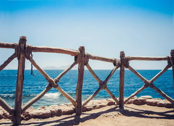 Costa del Mar Rosso con una recinzione in legno e ombrelloni a Sh — Foto Stock