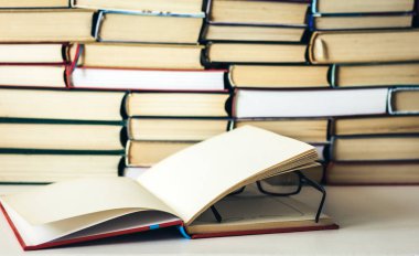 Kitap arkaplanı, açık kitap ve gözlük beyaz ahşap masa