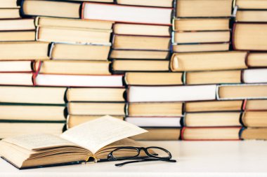 Kitap arkaplanı, açık kitap ve gözlük beyaz ahşap masa