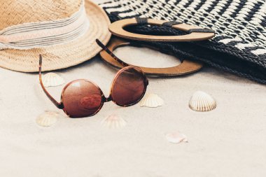 Tropikal bir plajda hasır şapka, çanta ve Güneş gözlükleri .