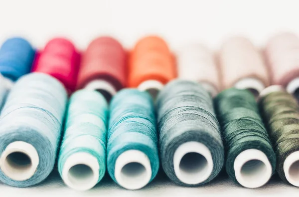 Bobine di filo da cucire colorate su sfondo bianco con spazio di copia — Foto Stock