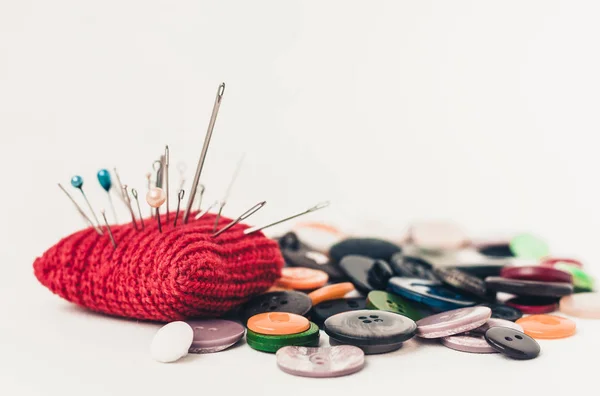 Almohadilla de aguja de punto rojo para coser y coser botones en ba blanco — Foto de Stock