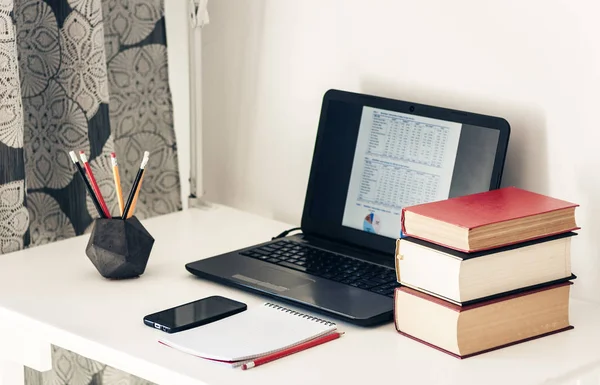 Notebook, stack knih, notebook, smartphone v kanceláři backgroun — Stock fotografie