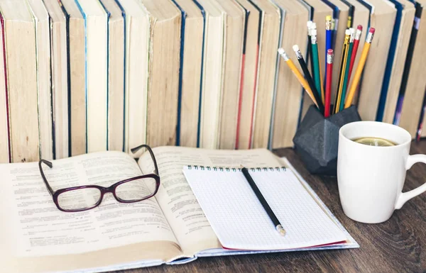 Pila de libros educación fondo, lápices, libro abierto, gafas — Foto de Stock