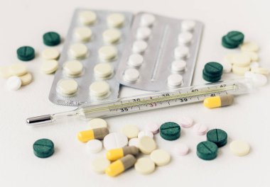 İlaç hapları ya da kapsüller beyaz arka planda su topladı