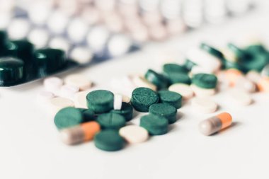 İlaç hapları ya da kapsüller beyaz arka planda su topladı