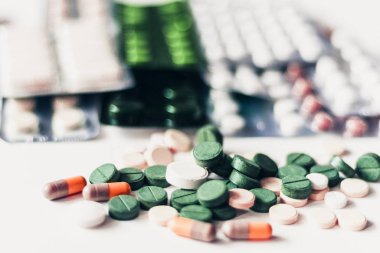 İlaç hapları ya da kapsüller beyaz arka planda su topladı