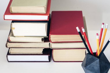 Eğitim için ofis arka planında eski kitap ve kalemler yığını