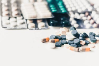 İlaç hapları ya da kapsüller beyaz arka planda su topladı