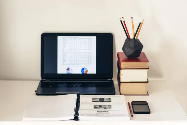 Laptop, pilha de livros, notebook, smartphone no backgroun escritório — Fotografia de Stock