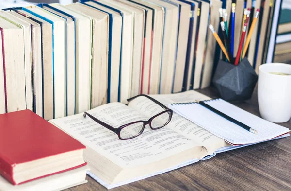 Egy halom könyv oktatási háttér, ceruzák, nyitott könyv, szemüveg — Stock Fotó