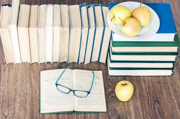 Stack of books, open book, glasses and green apples, background — Stock Photo, Image