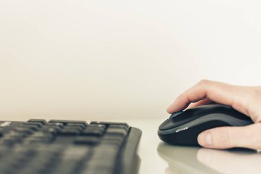 Fare kullanan ve klavye kombinasyonunda yazan kadının yakın plan resmi.