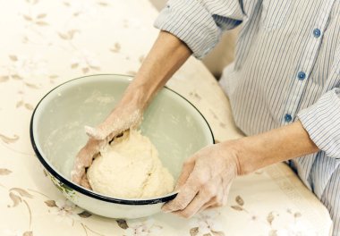 Metal bir blu içinde hamur işi yapmak için yoğurulan kadın elleri.