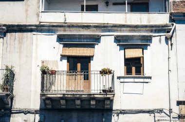 Tarihi bir binada saksıları ve bitkileri olan bir balkon. 