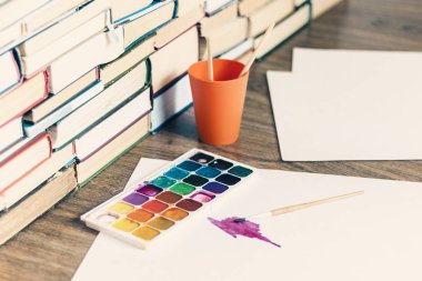 Suluboya boya, iyi kullanılmış fırçalar ve tahta üzerinde kağıt.