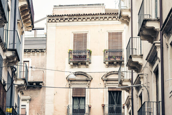 Traditional architecture of Sicily in Italy, typical street of Catania, facade of old buildings