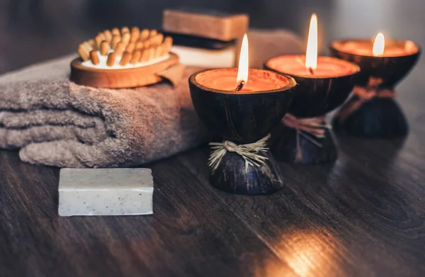 Burning spa aroma candles in coconut shell, handmade soap, towel — Stock Photo, Image