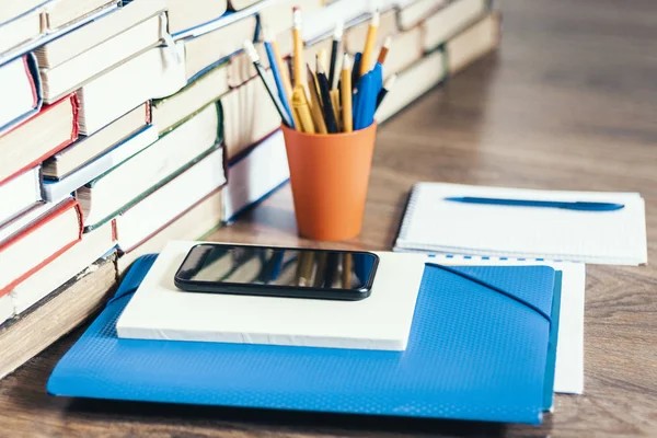 Pila de libros, libros de tapa dura, teléfono inteligente, carpeta de plástico, nota — Foto de Stock