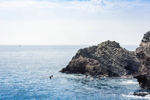 Los niños nadan cerca de las rocas de Acitrezza del cíclope, pilas de mar en — Foto de Stock