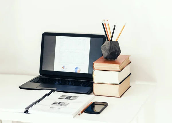 Laptop, stapel boeken, smartphone, notebook en potloden in conc — Stockfoto