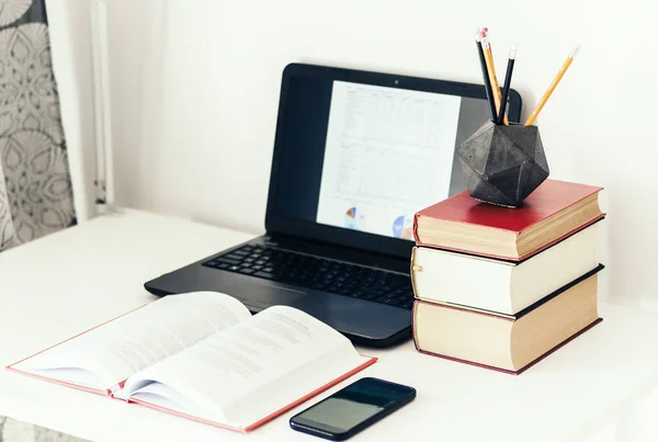 Laptop, pilha de livros, smartphone, notebook e lápis em conc — Fotografia de Stock
