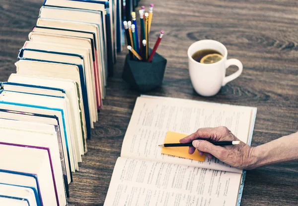 Pila de libros educación fondo, libro abierto, mano femenina con — Foto de Stock