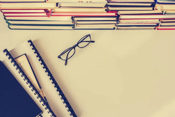 Books background, glasses and textbooks on white wooden table