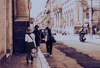 Sicilya 'da gün batımı tarihi Catani caddesinde yürüyen insanlarla.