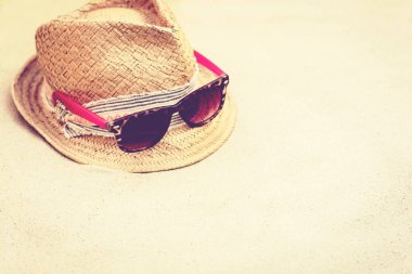 Tropik bir plajda hasır şapka ve pembe güneş gözlükleri. .