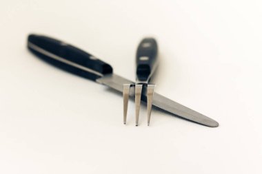 Bıçak ve çatal kesişmiş, beyaz arka planda izole edilmiş..