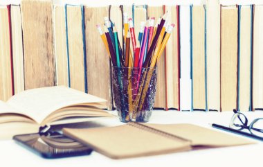 Ders kitabını, defteri, akıllı telefonu, kitap yığınını aç.