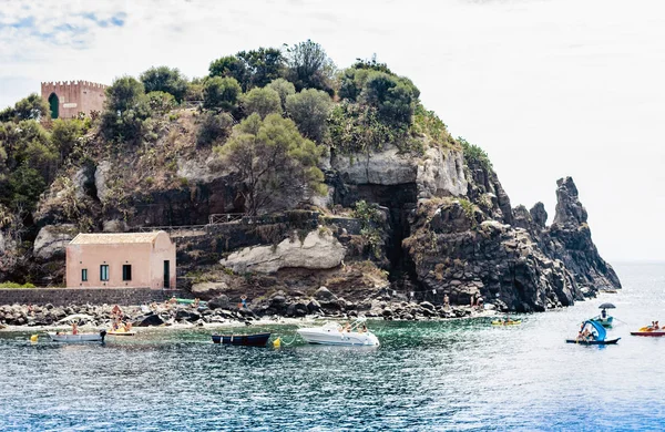 Rocky sea shore of Acitrezza next to Cyclops islands with island — Stock Photo, Image