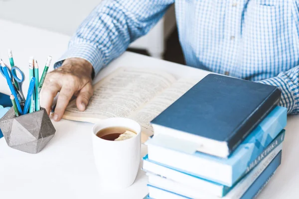 Hombre de camisa azul libro de lectura en un lugar de trabajo moderno y elegante con — Foto de Stock