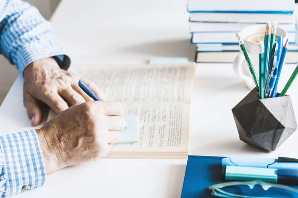 Hombre de camisa azul libro de lectura en un lugar de trabajo moderno y elegante con — Foto de Stock