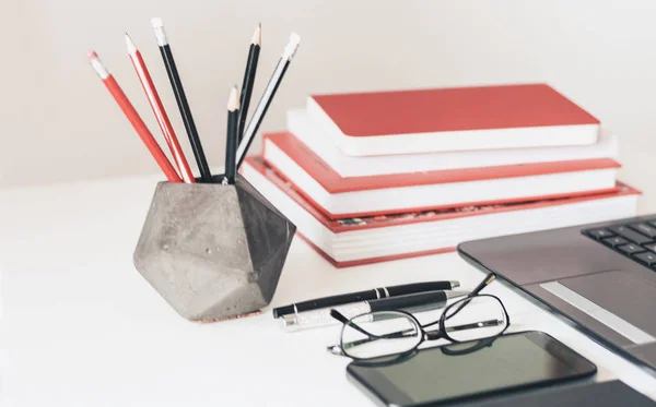 Laptop, smartphone, stapel boeken, notebook en potloden in conc — Stockfoto