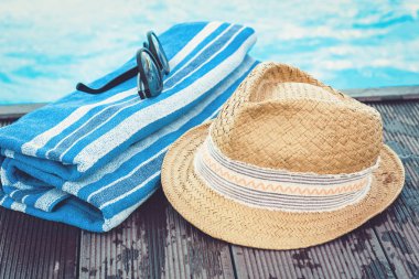 Eski yaz hasır hasır hasır plaj şapkası, güneş gözlüğü, mavi havlu.