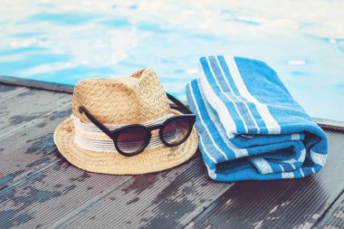 Eski yaz hasır hasır hasır plaj şapkası, güneş gözlüğü, mavi havlu.