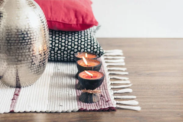 Confortable décor intérieur de la maison, des bougies brûlantes dans la coque de noix de coco sur un — Photo