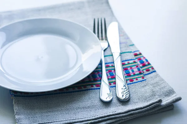 夕食のテーブル設定:白いプレート、フォーク、 2つのナイフ — ストック写真