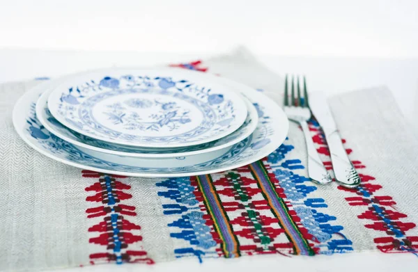 Table setting for dinner: white and blue plates, a fork, a knife — Stock Photo, Image