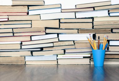 Eski kitap ve kalemler, eğitim kavramının gerisinde.