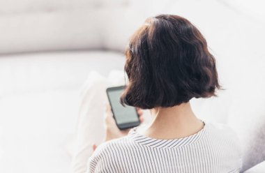 Gri koltukta gözlüklü, orta yaşlı esmer kadın.