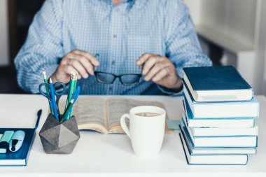 Orta yaşlı, mavi gömlekli, modern stil hakkında kitap okuyan bir adam.