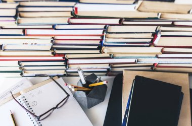 Ders kitabını, defteri, dizüstü bilgisayarı, kitap yığınını aç