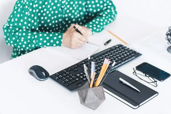 Close-up van de handen van middelbare leeftijd vrouw in groene blouse typen op ke — Stockfoto