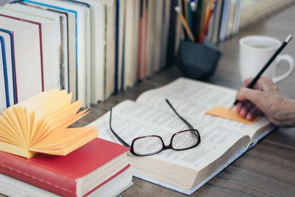 Pila de libros educación fondo, mano femenina hace notas nea — Foto de Stock