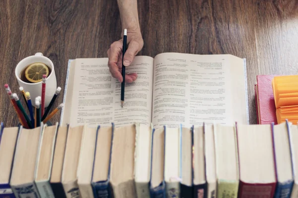 Pila de libros educación fondo, mano femenina hace notas nea — Foto de Stock